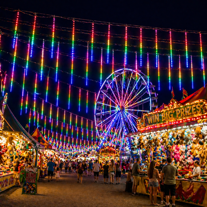 Festive fairground scene with LED Meteor Shower Lights Outdoor and a Ferris wheel at night.