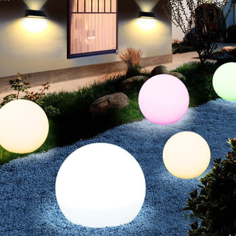 Colorful spherical outdoor lights on a garden path with a house in the background.