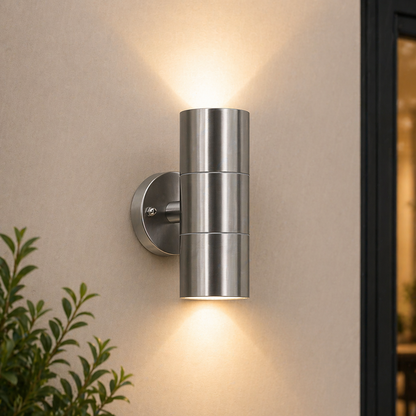 Outdoor Wall Lights Waterproof – Up & Down fixture on a beige wall with a plant in the foreground.