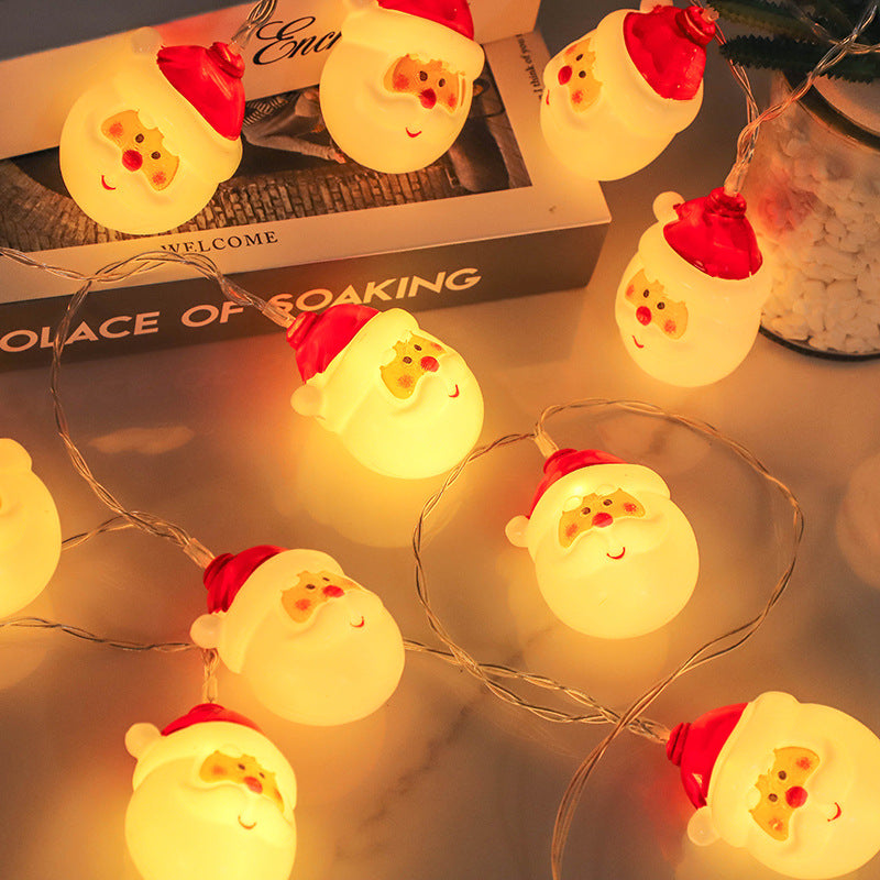 Santa Claus LED String Lights on a surface with a magazine in the background.