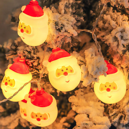 Santa Claus LED String Lights  with red hats and white beards, hanging against a snowy tree background.