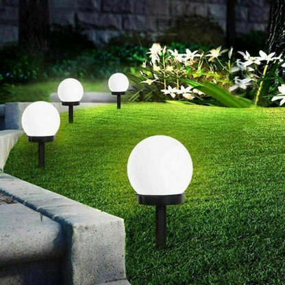 Solar Ball Garden Lights Outdoor on grass with a stone path and plants in the background