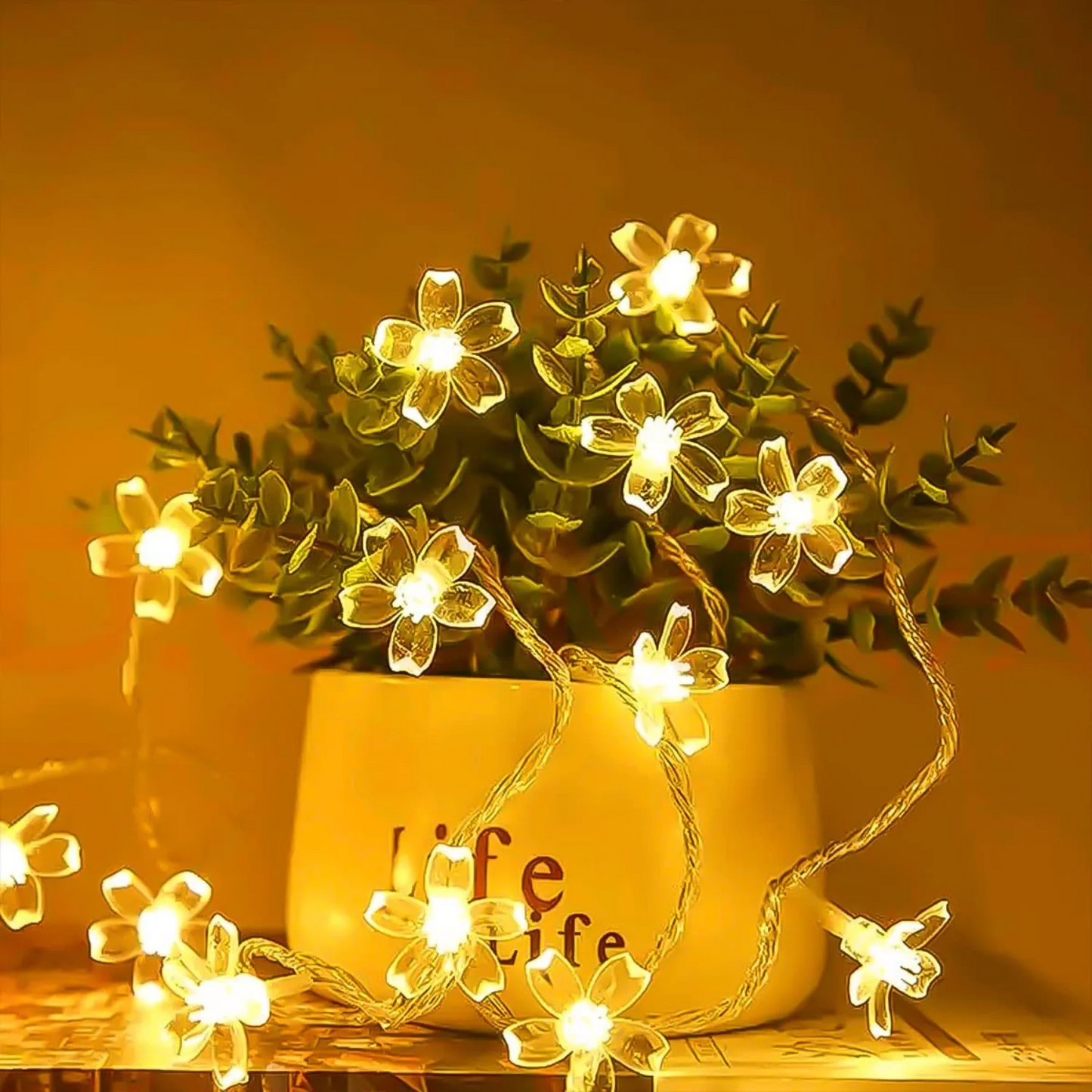 Solar Flower Fairy String Lights on a plant with a warm glow