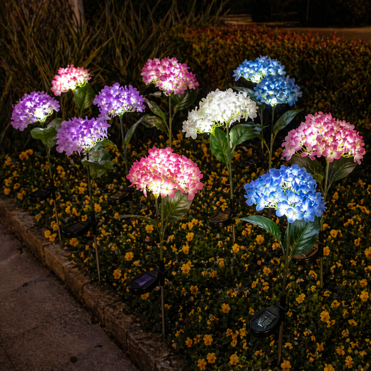 Solar Hydrangea Garden Lights on a garden bed at night.