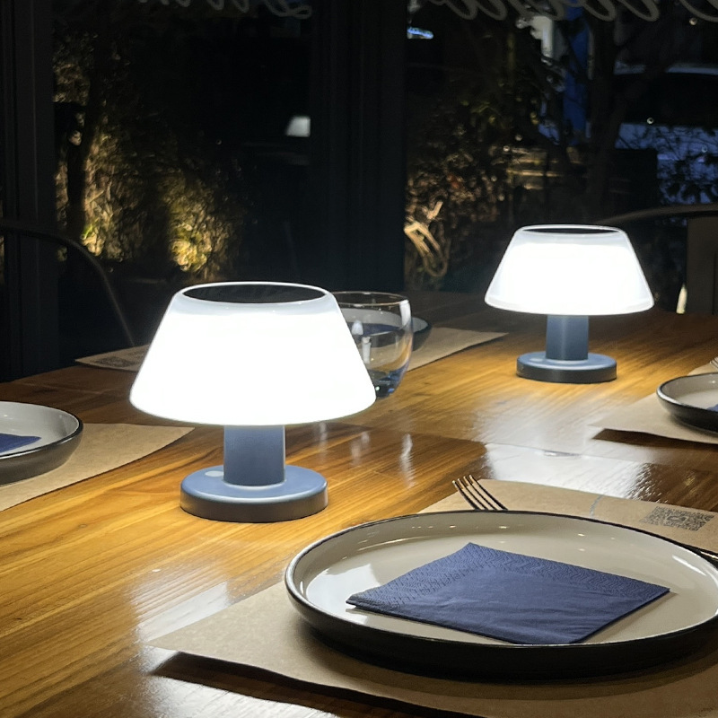 Solar Table Lamp Outdoor on a wooden table with plates and cutlery.