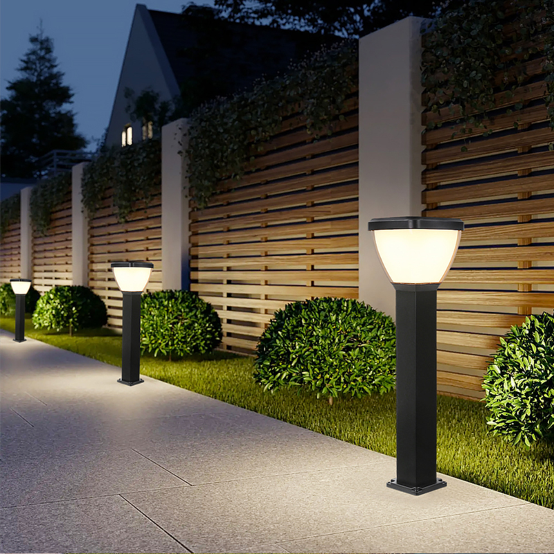 Waterproof Outdoor Solar LED Pillar Light on black posts in a garden setting with a wooden fence and house in the background.