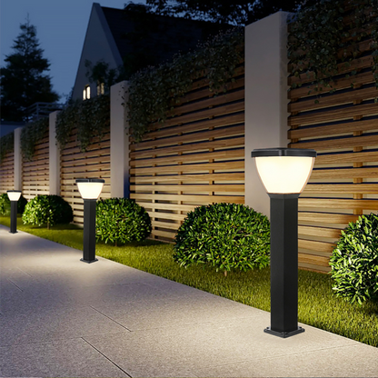 Waterproof Outdoor Solar LED Pillar Light on black posts in a garden setting with a wooden fence and house in the background.