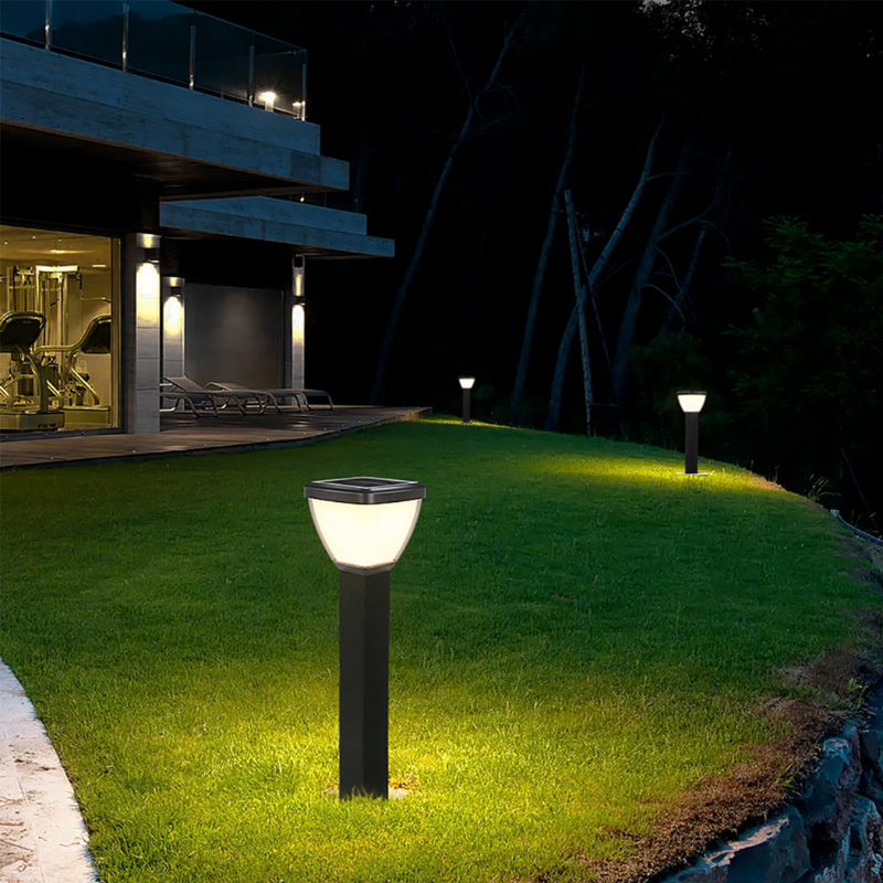 Waterproof Outdoor Solar LED Pillar Light illuminating a grassy area outside a modern house at night.